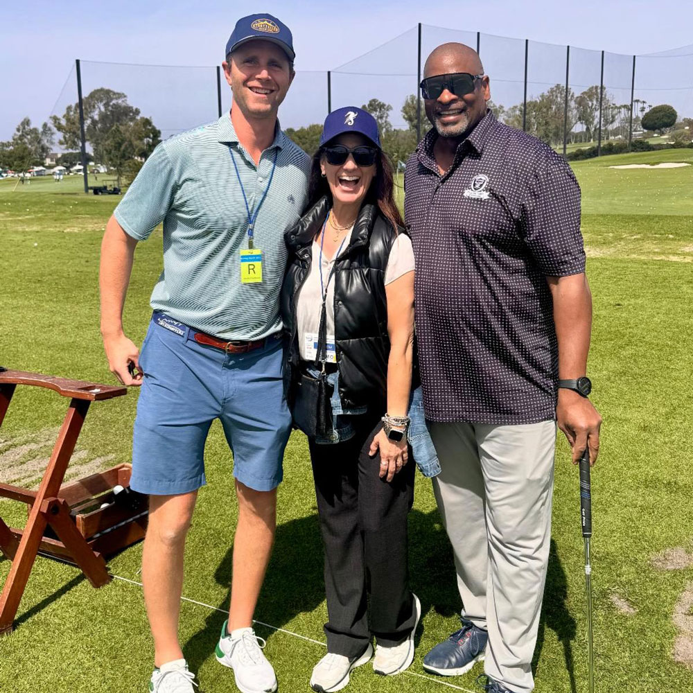 december_newsletter_2025_9 Three people stand together on a golf course smiling for a photo, with one holding a golf club.