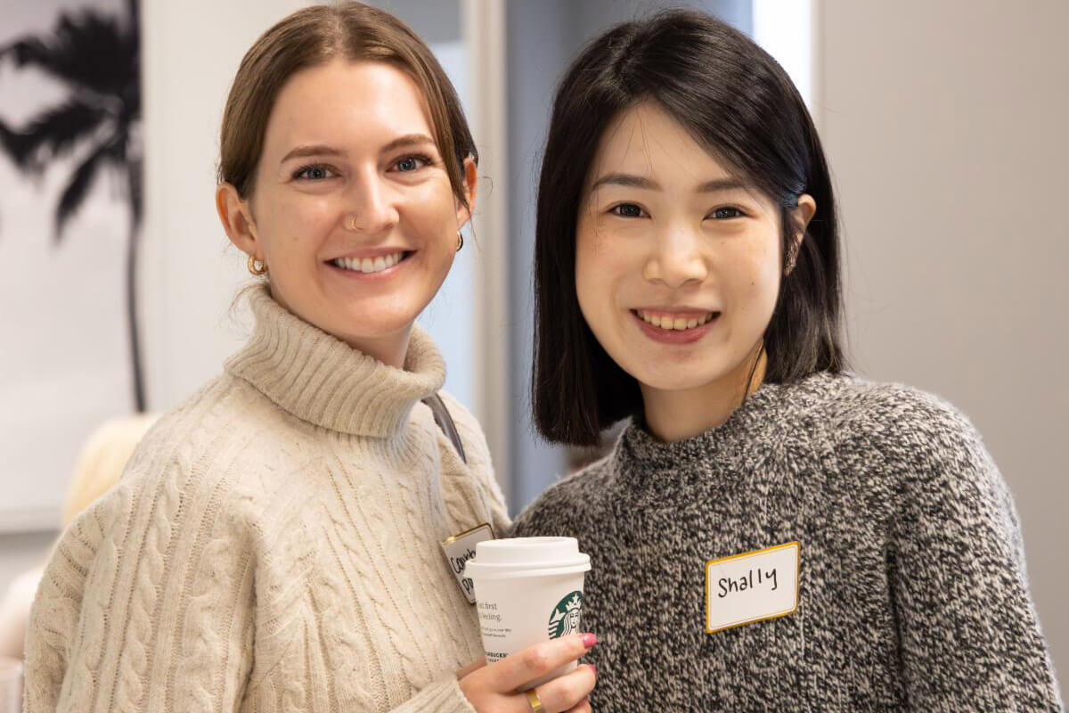 A small group sits together in conversation in a relaxed, lounge-style indoor setting.
